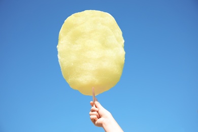 Photo of Woman holding white cotton candy against blue sky