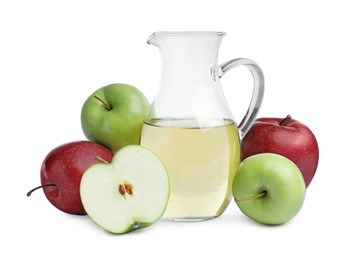 Different ripe apples and jug of juice on white background