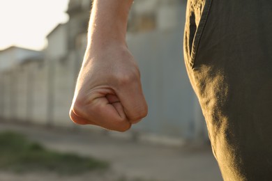 Photo of Angry man with clenched fist outdoors, closeup