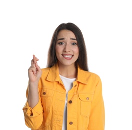 Nervous young woman holding fingers crossed on white background. Superstition for good luck 