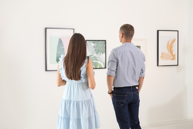 Young couple at exhibition in art gallery