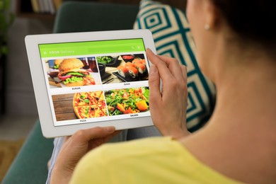 Woman using tablet for ordering food online at home, closeup. Concept of delivery service