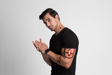 Handsome man with beautiful tattoo sketches on white background