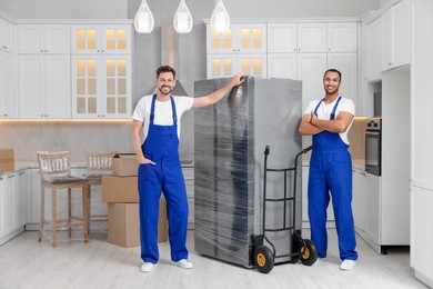 Photo of Male movers with refrigerator in new house