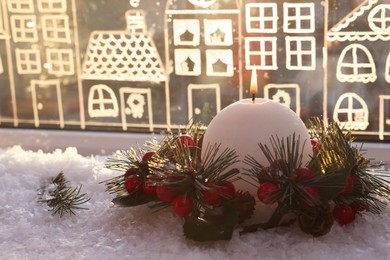 Beautiful burning candle with Christmas decor near window, space for text