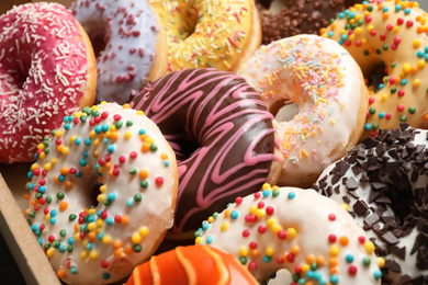 Yummy glazed donuts with sprinkles, closeup view