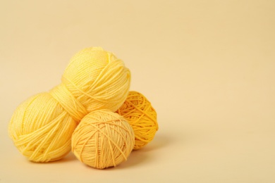 Soft yellow woolen yarns on beige background. Space for text