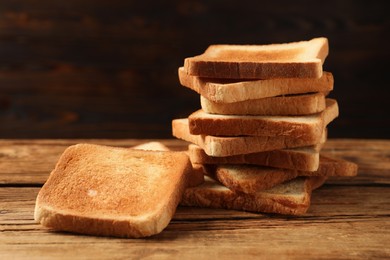 Slices of tasty toasted bread on wooden table