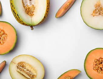 Cut different types of melons on white background, flat lay. Space for text
