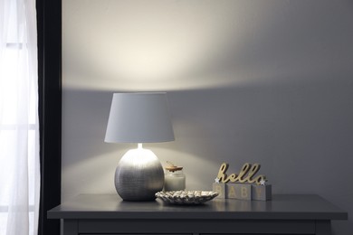 Stylish lamp and decor on grey table indoors. Interior design