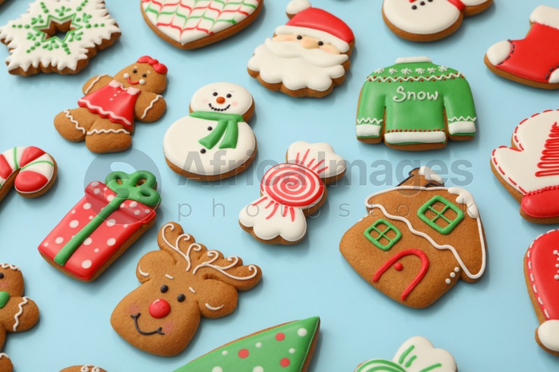 Different Christmas gingerbread cookies on light blue background, closeup