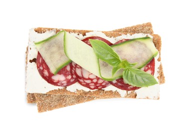 Fresh rye crispbreads with salami, cream cheese and cucumber on white background, top view