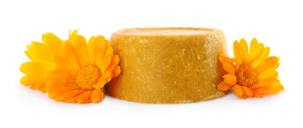 Yellow solid shampoo bar and flowers on white background. Hair care
