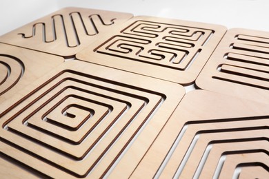 Photo of Wooden finger labyrinths on white background, closeup. Montessori toy