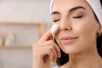 Woman using silkworm cocoon in skin care routine at home, closeup. Space for text