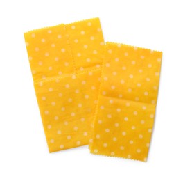 Yellow reusable beeswax food wraps on white background, top view