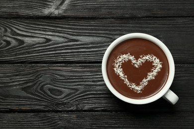 Photo of Cup of hot chocolate with heart shaped decoration on black wooden table, top view. Space for text