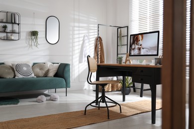 Stylish home office interior with sofa and comfortable workplace