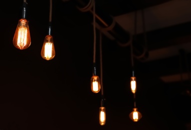 Glowing lamp bulbs in dark room. Interior element