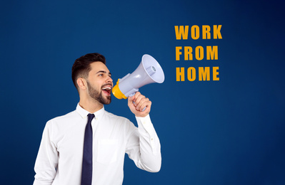 Young man with megaphone on blue background. Work from home during coronavirus outbreak