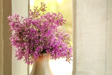 Beautiful lilac flowers in vase near window indoors, closeup