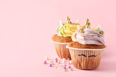 Photo of Cute sweet unicorn cupcakes on pink background, space for text