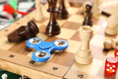 Spinner, pieces and dices on chess board, closeup. Tabletop games