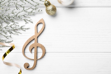 Flat lay composition with music note on white wooden background, space for text. Christmas celebration
