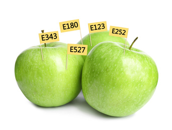 Fresh apples with E numbers on white background. Harmful food additives 