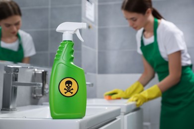 Photo of Spray of toxic household chemical with warning sign in bathroom