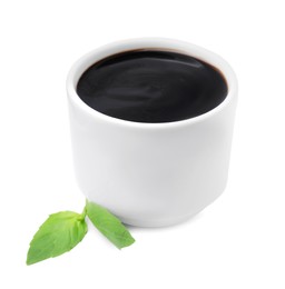 Photo of Balsamic glaze and basil leaves on white background
