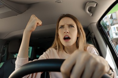 Stressed angry woman in driver's seat of modern car
