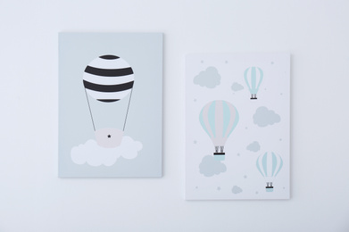 Photo of Adorable pictures of air balloons on white wall. Children's room interior elements