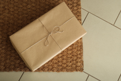 Parcel on rug near doorway. Delivery service