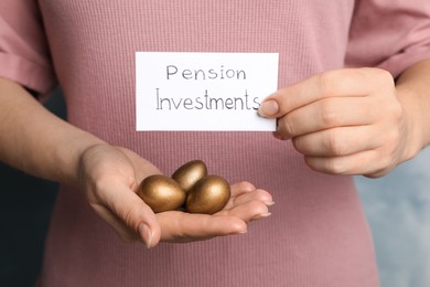 Woman holding golden eggs and card with phrase Pension Investments, closeup