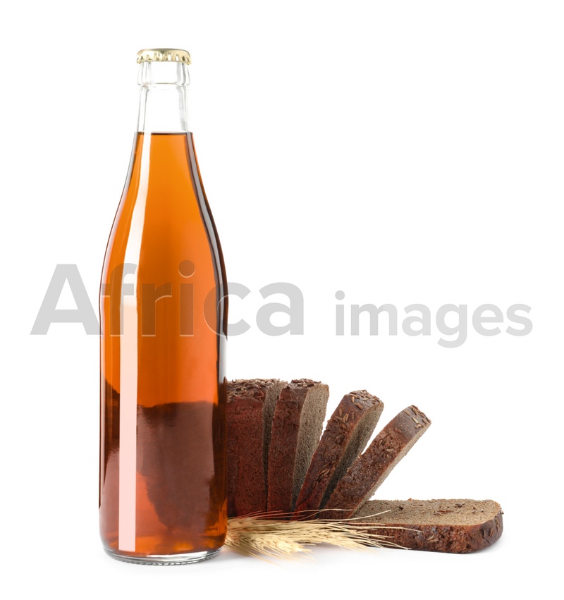 Photo of Bottle of delicious fresh kvass, spikelets and bread on white background