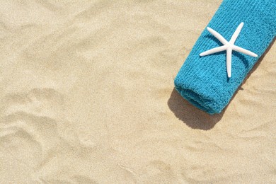 Photo of Towel with starfish on sand outdoors, top view and space for text. Beach accessory