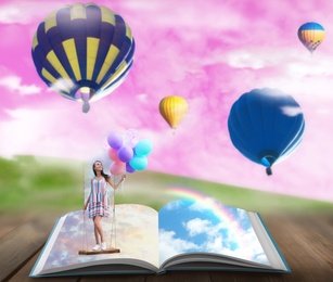 Fantasy worlds in fairytales. Book, hot air balloons and pink sky over misty green meadow on background