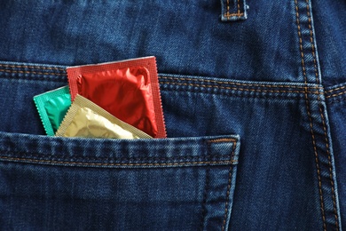 Closeup view of jeans with condoms in pocket. Safe sex concept
