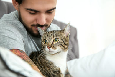 Man with cat on bed at home. Friendly pet
