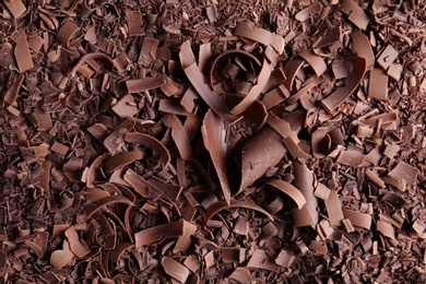 Yummy chocolate curls for decor as background, top view