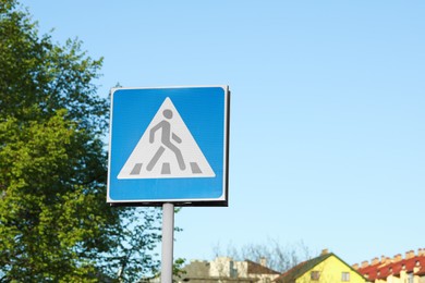 Post with Pedestrian Crossing traffic sign in city on sunny day
