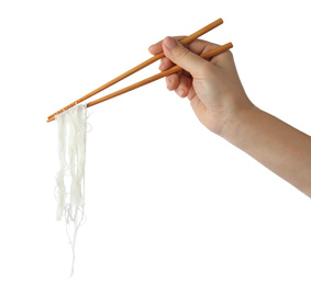 Woman holding chopsticks with tasty cooked rice noodles on white background, closeup
