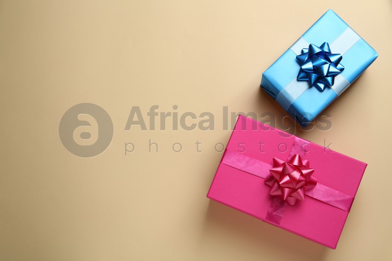 Colorful gift boxes on beige background, flat lay. Space for text