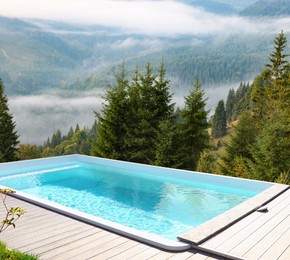 Outdoor swimming pool at luxury resort and beautiful view of mountains on sunny day