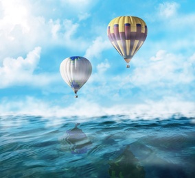 Dream world. Hot air balloons in sky with clouds over misty sea