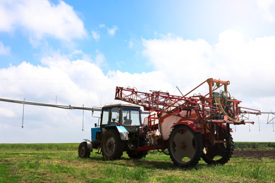 Modern agricultural equipment in field under cloudy sky