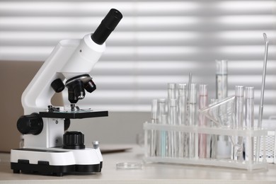 Photo of Modern medical microscope on wooden table in laboratory, space for text
