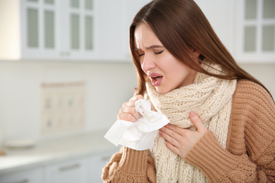 Sick young woman coughing at home. Influenza virus
