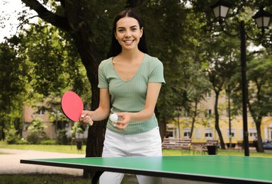 Young woman playing ping pong in park